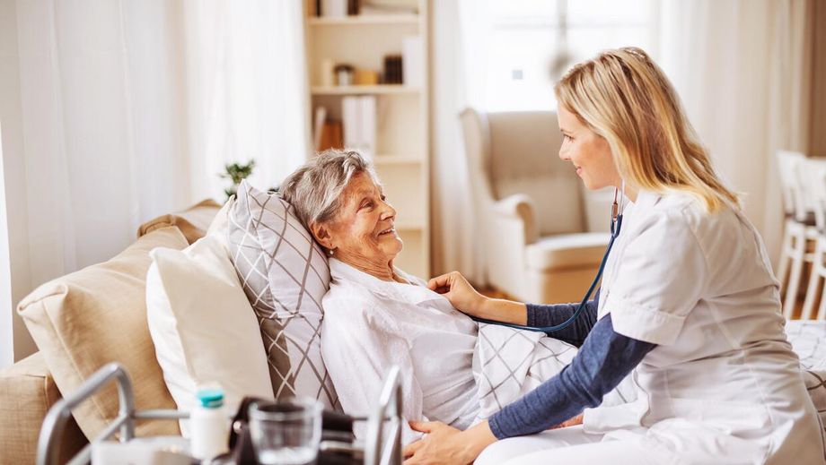 Eine alte Frau wird von einer Pflegerin versorgt