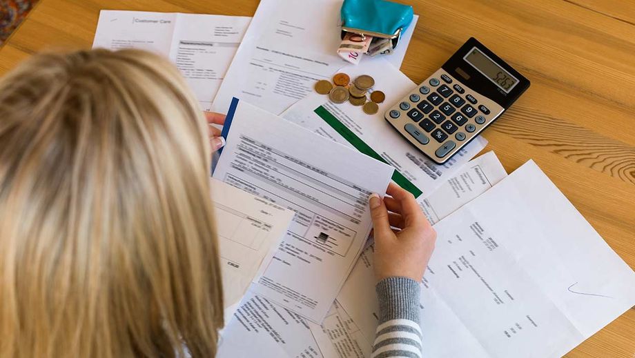 Frau sitzt über der Nebenkostenabrechnung