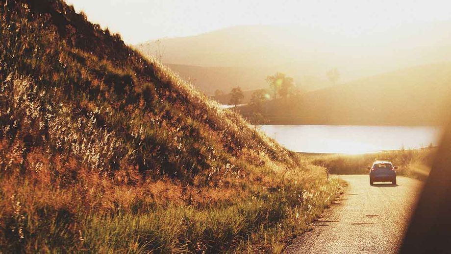 Auto auf Straße Richtung Sonne