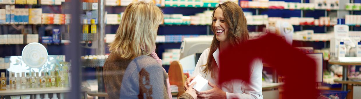 Kundin und Verkäuferin befinden sich in einer Apotheke