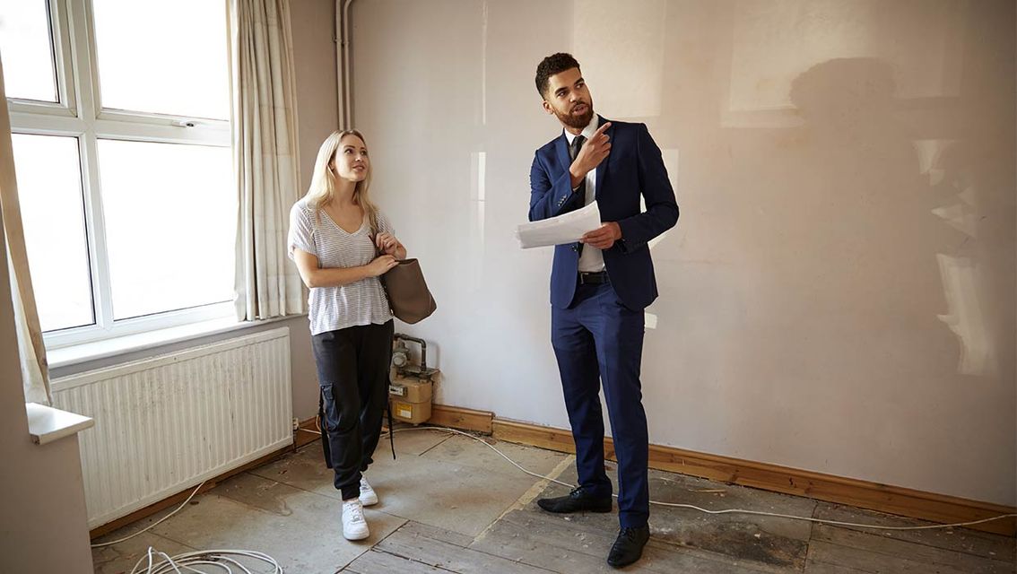 Makler und Interessentin besichtigen eine Wohnung.