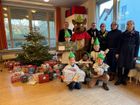 Die Geschenkeübergabe (von links): Caritasdirektor Jean-Pierre Schneider, Maskottchen Robbie, Polizeipräsident Frank Hoever, die Lengsdorfer Bezirksdienstbeamtin Polizeihauptkommissarin Sandra Scherer, Diakonie-Geschäftsführerin Andrea Elsmann und Stefanie Schlegel von "update". Im Vordergrund die Botschafterkinder von Robin Good.