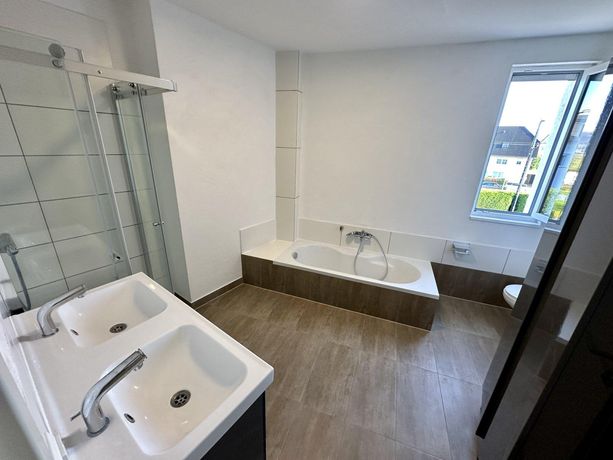 Großzügige Dusche und Wanne in harmonischer Raumgestaltung